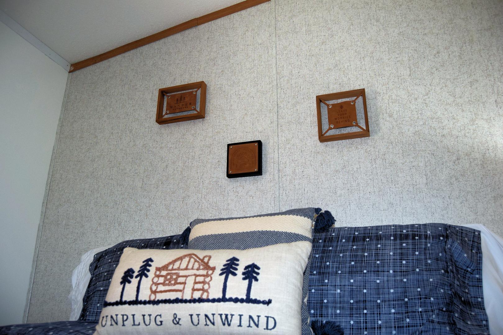 Close up of bedroom pillow saying "Unplug & Unwind"